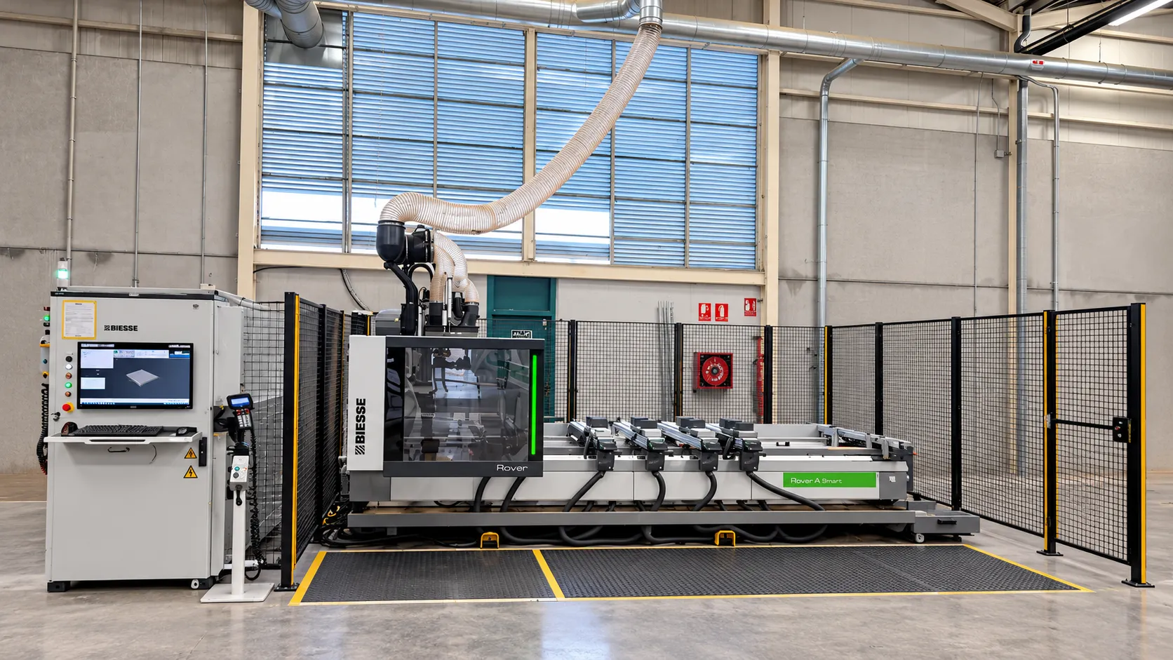 Centro de mecanizado de control numérico Biesse Rover A Smart, con su panel de control y el vallado de seguridad